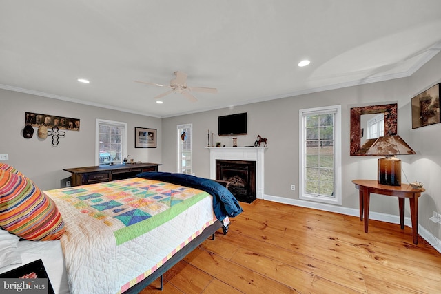 bedroom featuring ceiling fan, light wood-type flooring, and ornamental molding