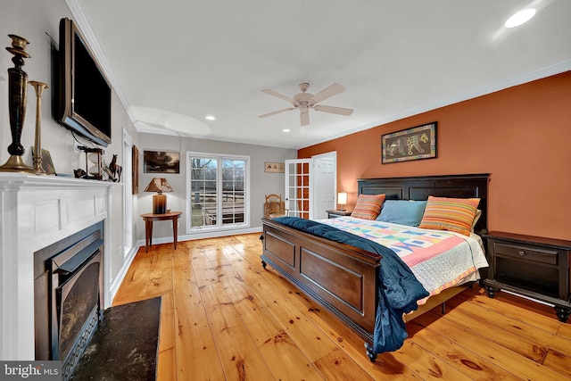 bedroom featuring ceiling fan, crown molding, and light hardwood / wood-style floors