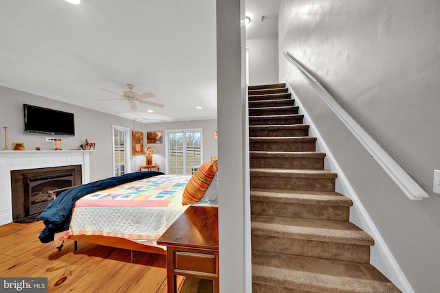 bedroom with ceiling fan, wood-type flooring, and crown molding