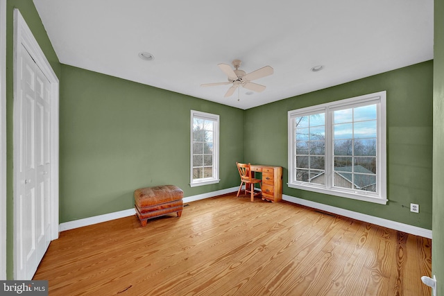 unfurnished room with light hardwood / wood-style floors, ceiling fan, and a healthy amount of sunlight