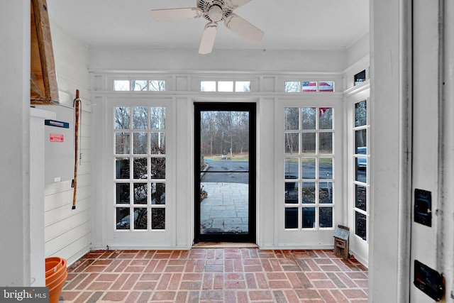 entryway featuring ceiling fan and wooden walls