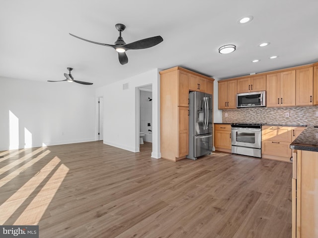 kitchen with light brown cabinets, backsplash, ceiling fan, appliances with stainless steel finishes, and light hardwood / wood-style floors