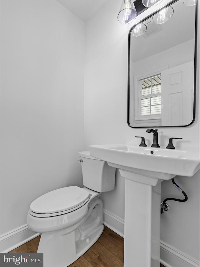 bathroom featuring hardwood / wood-style floors and toilet