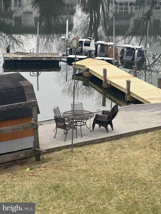 view of dock featuring a water view and a lawn