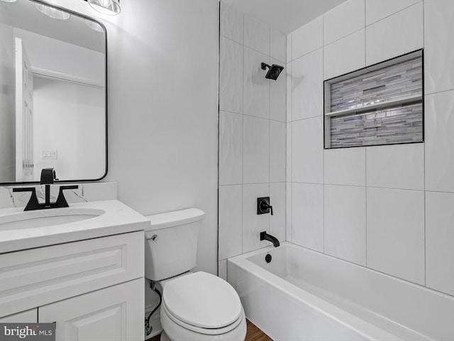 full bathroom featuring vanity, tiled shower / bath combo, and toilet