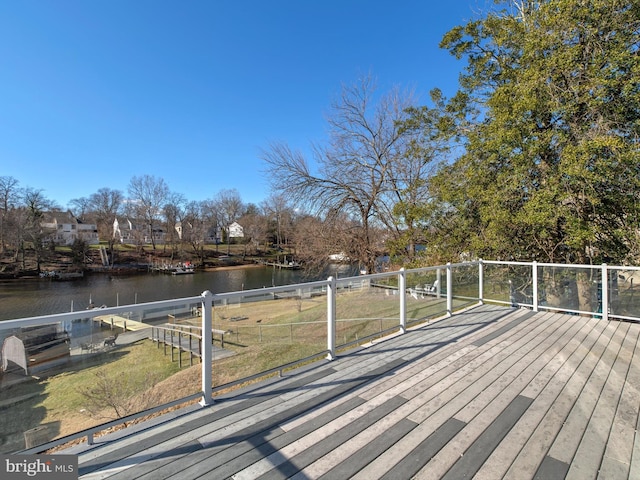 wooden deck featuring a lawn and a water view