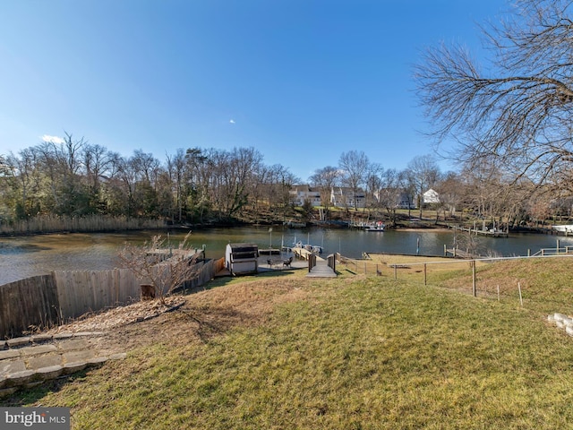 dock area with a yard and a water view