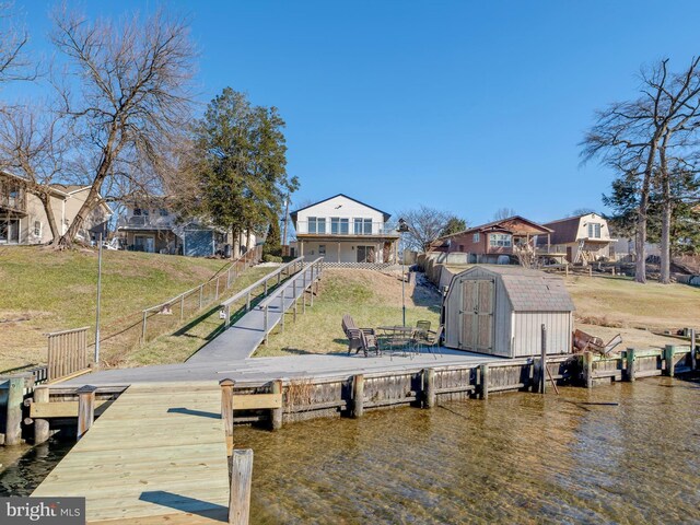 dock area with a yard and a water view