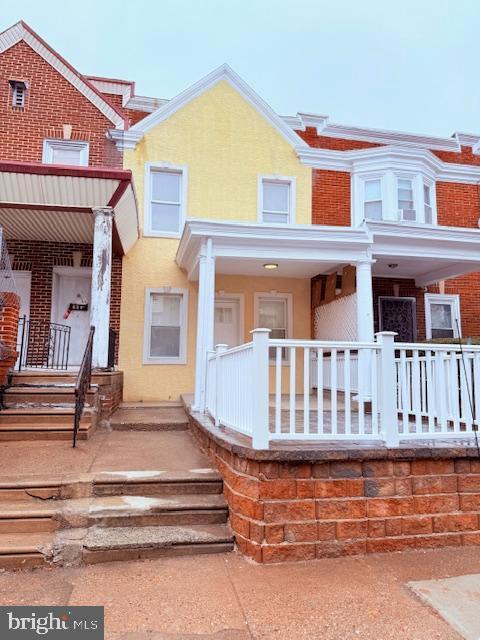 back of property featuring covered porch