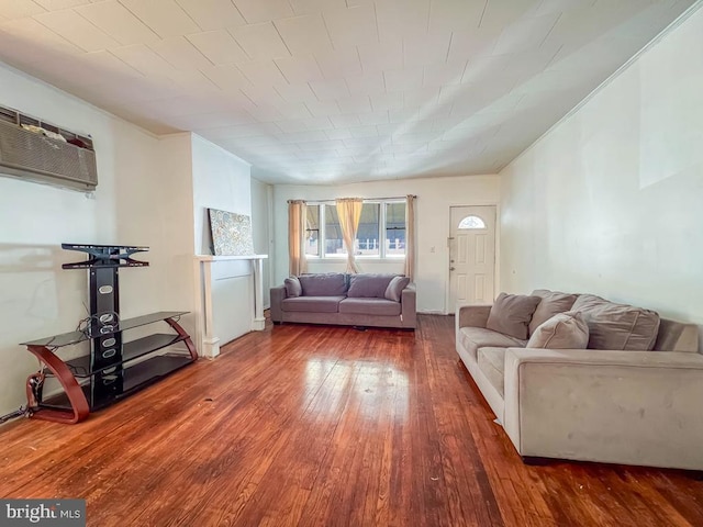 unfurnished living room featuring an AC wall unit and dark wood-type flooring