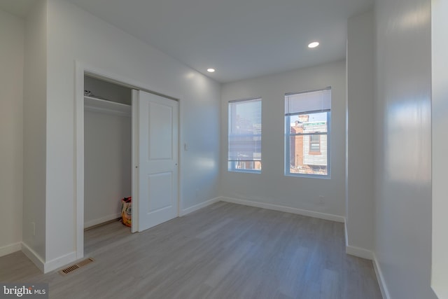 unfurnished bedroom with light wood-type flooring and a closet