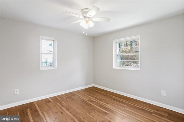 spare room featuring hardwood / wood-style flooring, ceiling fan, and a healthy amount of sunlight