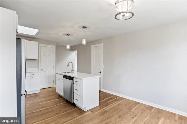 kitchen with stainless steel appliances, a kitchen island with sink, sink, decorative light fixtures, and white cabinetry