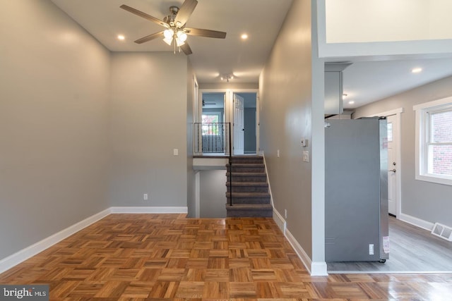 staircase with ceiling fan and parquet flooring