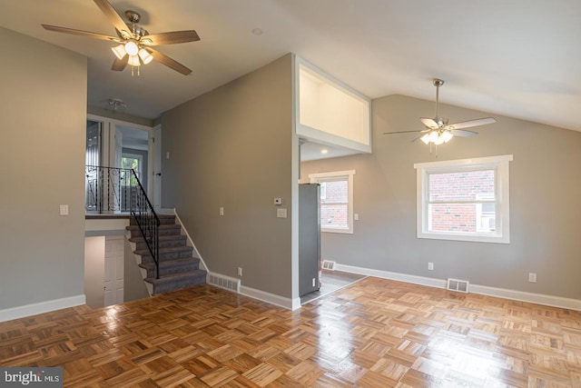 spare room with light parquet flooring, vaulted ceiling, and ceiling fan