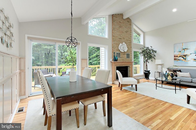 5284 Davis Ford Rd, Woodbridge, VA 22192 - dining space featuring light wood-style floors, high vaulted ceiling, beamed ceiling, and a fireplace