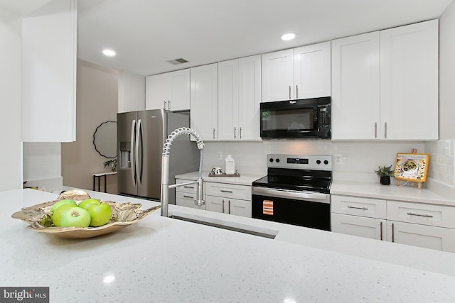 5284 Davis Ford Rd, Woodbridge, VA 22192 - kitchen featuring stainless steel appliances, white cabinets, backsplash, recessed lighting, and light stone counters