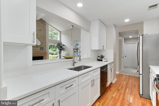5284 Davis Ford Rd, Woodbridge, VA 22192 - kitchen with a sink, appliances with stainless steel finishes, light wood finished floors, white cabinetry, and lofted ceiling