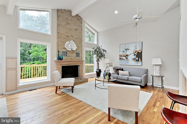 5284 Davis Ford Rd, Woodbridge, VA 22192 - living room with high vaulted ceiling, beamed ceiling, light wood-type flooring, a brick fireplace, and a ceiling fan