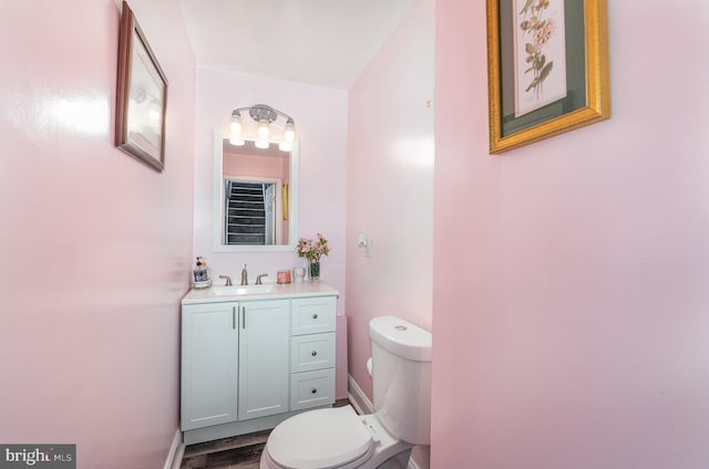 bathroom with hardwood / wood-style flooring, vanity, and toilet