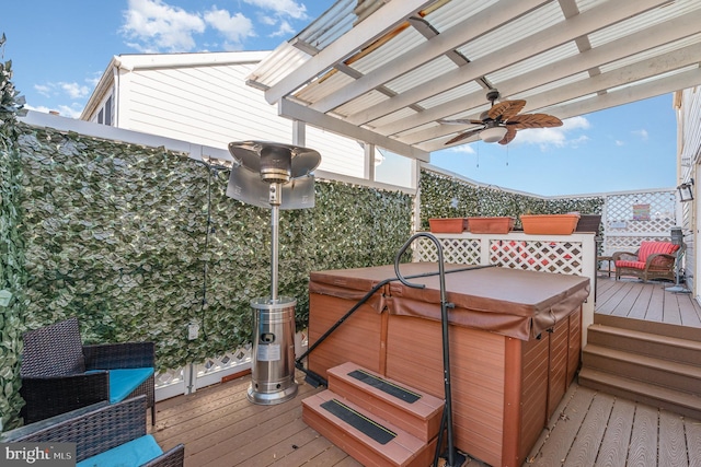 wooden deck with a hot tub, ceiling fan, and a pergola