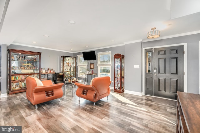 interior space with bar area, ornamental molding, and light wood-type flooring