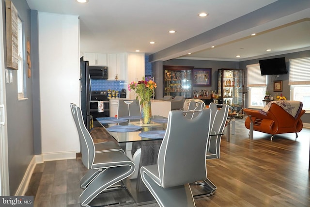 dining room featuring crown molding and dark wood-type flooring