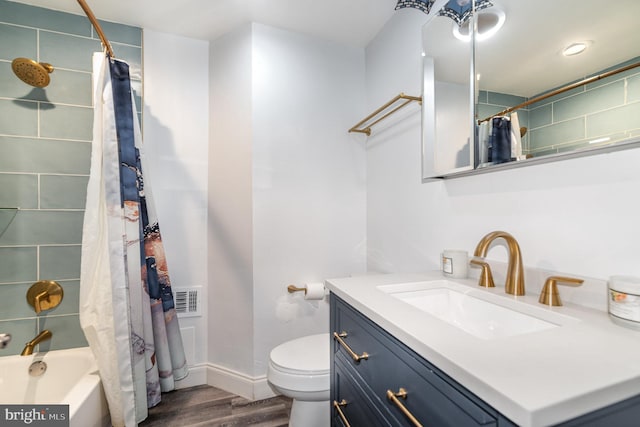 full bathroom featuring wood-type flooring, vanity, shower / bath combo with shower curtain, and toilet