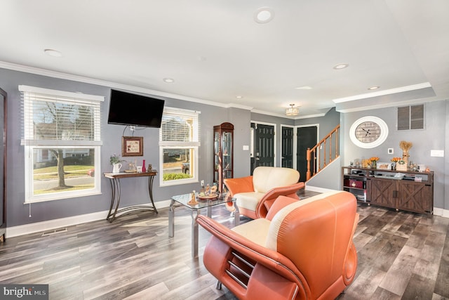 living room with hardwood / wood-style floors, ornamental molding, and a wealth of natural light