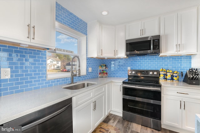 kitchen featuring dark wood-type flooring, sink, tasteful backsplash, appliances with stainless steel finishes, and white cabinets