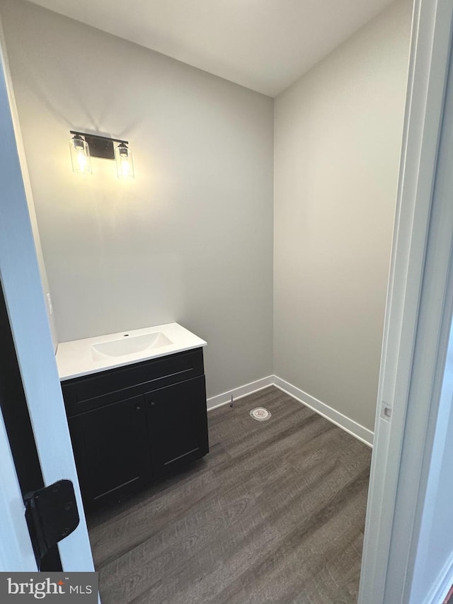 bathroom with vanity, baseboards, and wood finished floors