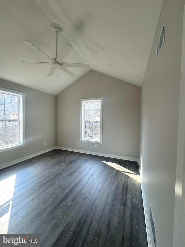 additional living space with vaulted ceiling, dark wood-type flooring, and visible vents