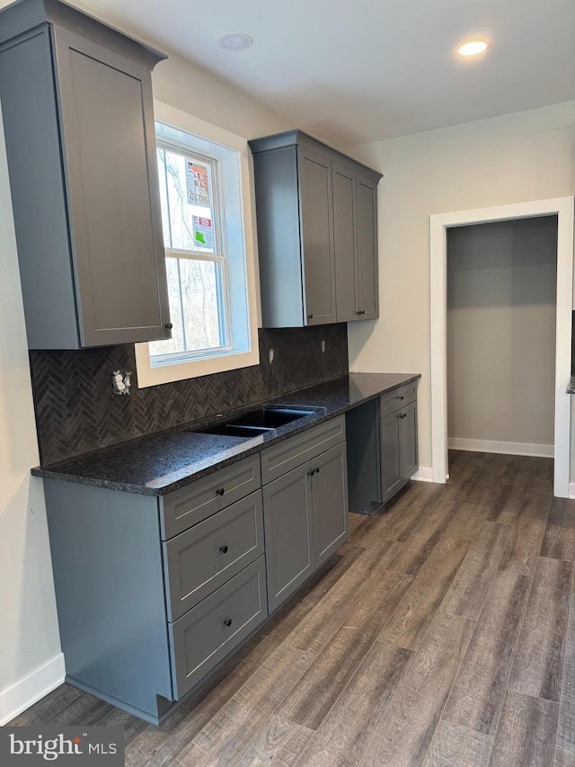 kitchen featuring dark countertops, gray cabinets, and dark wood-type flooring