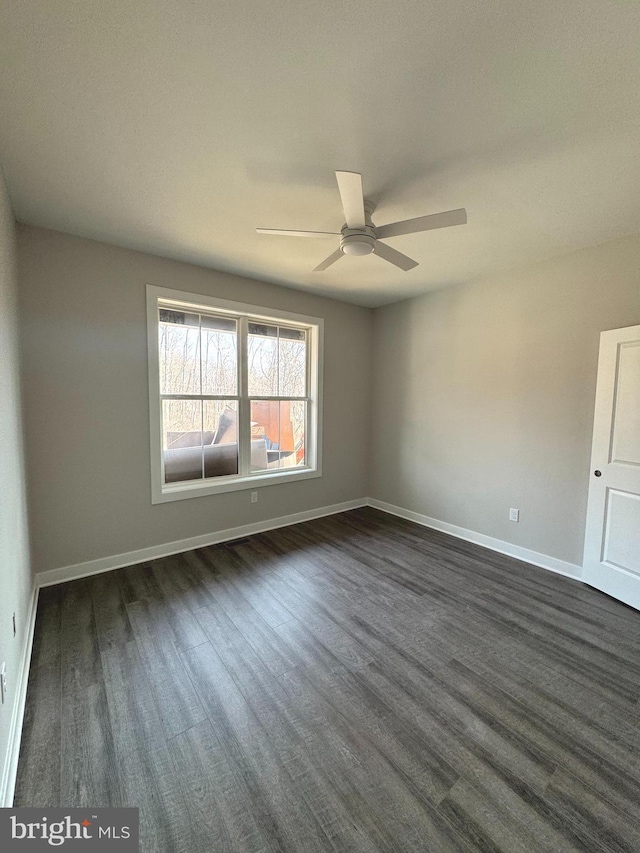 empty room with dark wood-type flooring, ceiling fan, and baseboards