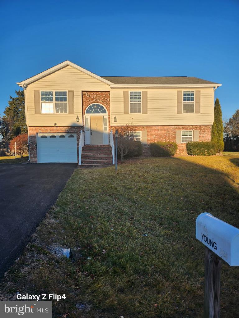 raised ranch with a garage and a front lawn