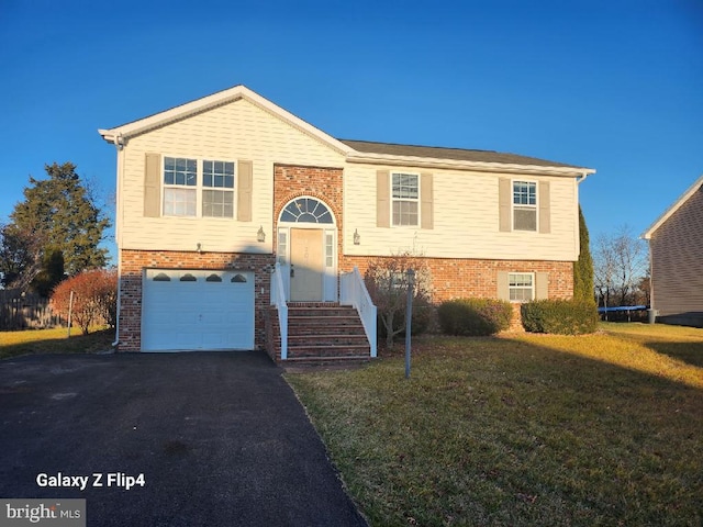 split foyer home with a garage and a front yard