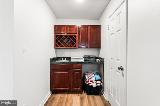 bar featuring sink and light hardwood / wood-style flooring