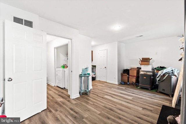 interior space featuring wood-type flooring and washing machine and clothes dryer