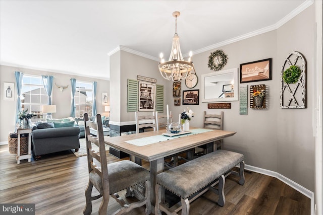 dining room featuring dark hardwood / wood-style flooring, ornamental molding, and a chandelier