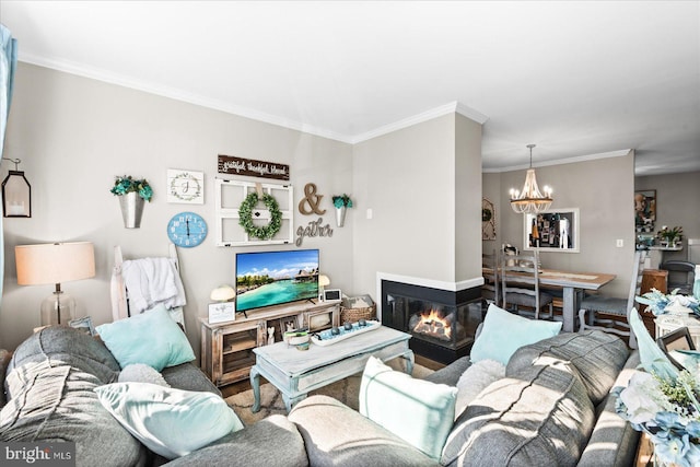 living room featuring crown molding, a multi sided fireplace, and a notable chandelier