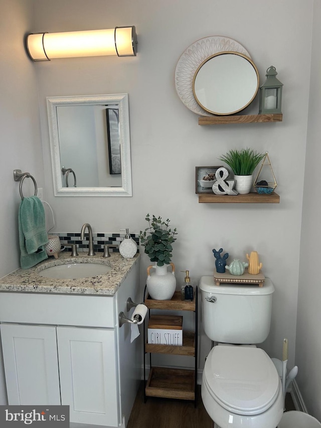 bathroom featuring vanity, hardwood / wood-style flooring, and toilet