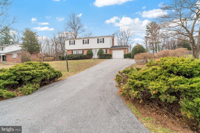 view of front of house featuring a garage and a front lawn