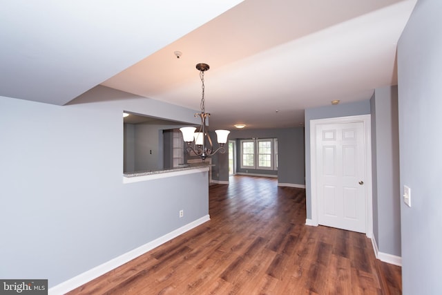 unfurnished dining area with a chandelier and dark hardwood / wood-style flooring