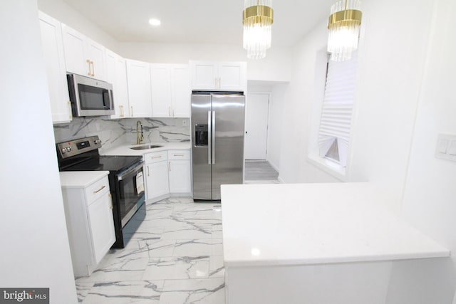 kitchen featuring sink, stainless steel appliances, pendant lighting, decorative backsplash, and white cabinets