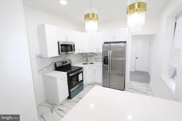 kitchen featuring white cabinets, hanging light fixtures, and appliances with stainless steel finishes