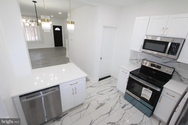 kitchen featuring white cabinetry, hanging light fixtures, a notable chandelier, decorative backsplash, and appliances with stainless steel finishes