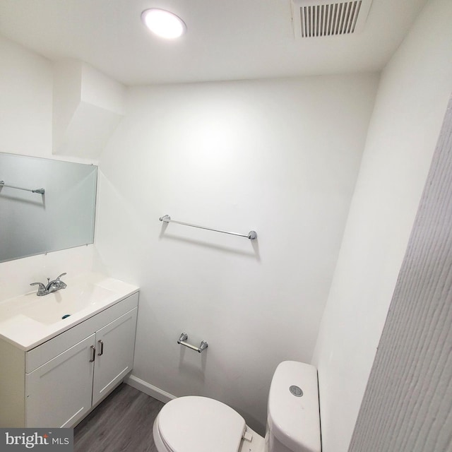 bathroom featuring hardwood / wood-style floors, vanity, and toilet