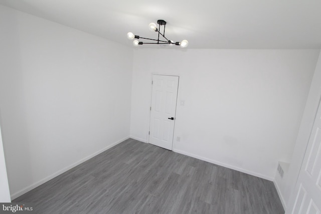 unfurnished room featuring wood-type flooring and a chandelier