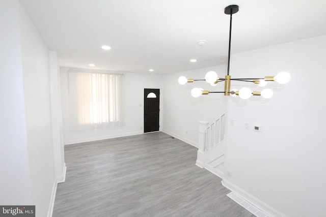 foyer entrance with hardwood / wood-style floors and a chandelier