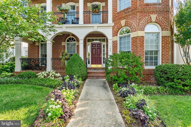 property entrance with a balcony and a yard